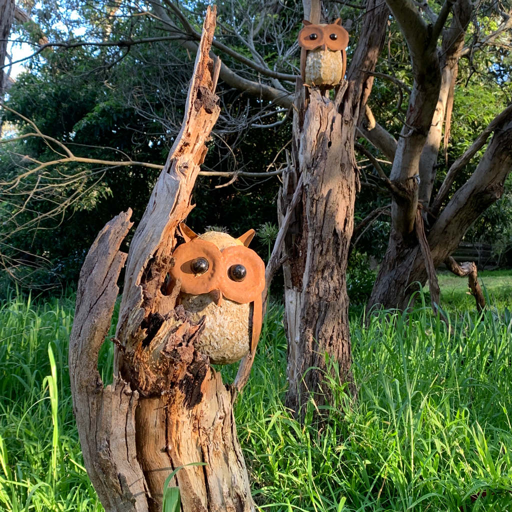 big eyed owl sculpture in garden setting